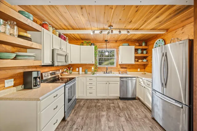 a kitchen with a sink refrigerator and cabinets