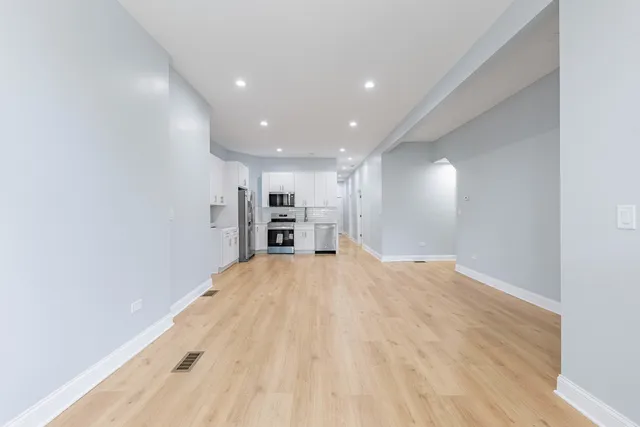 a view of empty room with wooden floor