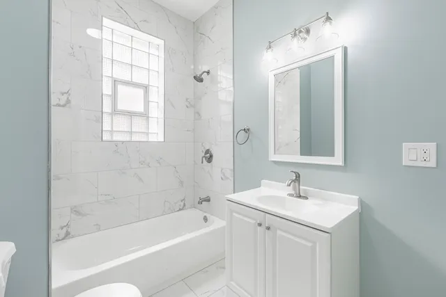 a bathroom with a bathtub a sink a mirror and a shower