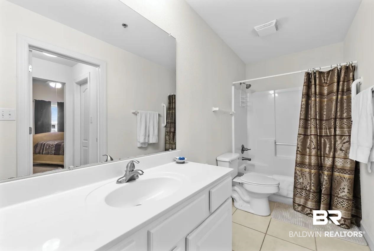 27770 Canal Road, Unit 2502 Orange Beach, AL 36561 - Photo 25 of 55 Ensuite bathroom featuring shower / tub combo with curtain, vanity, and light tile patterned floors
