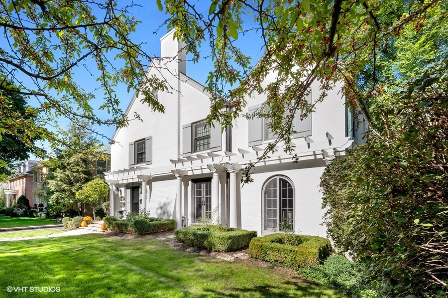 111 Robsart Road Kenilworth, IL 60043 - Photo 4 of 49 a view of a white house with a large trees and plants