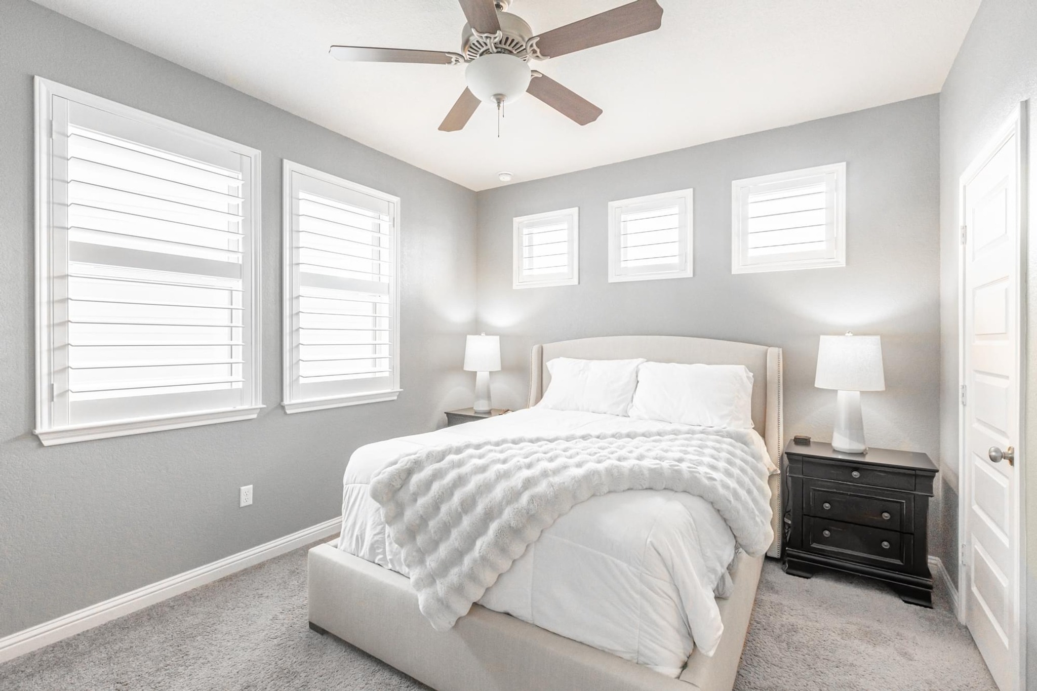 7801 Frida Bend Austin, TX 78744 - Photo 13 of 26 Well-lit sleeping quarters with a ceiling fan, carpet, and windows with plantation shutters.