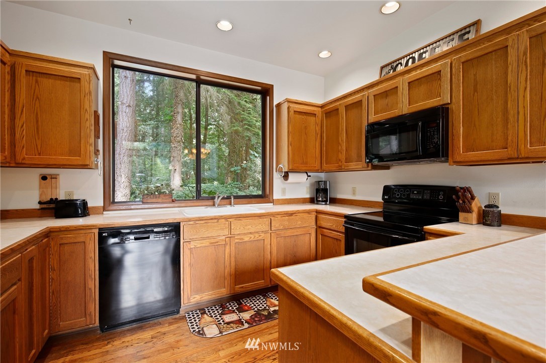 20830 Southeast 145th Street Renton, WA 98059 - Photo 8 of 39 a kitchen with a stove a sink and a microwave