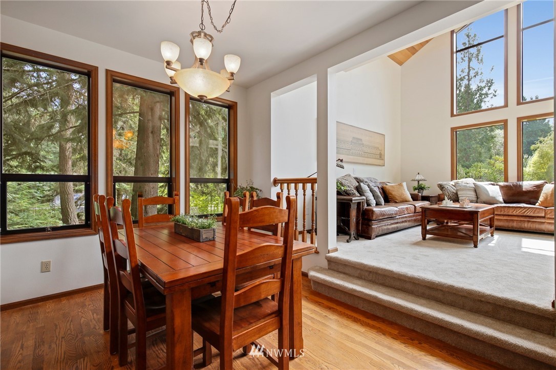 20830 Southeast 145th Street Renton, WA 98059 - Photo 9 of 39 a dining room with wooden floor a chandelier a wooden table and chairs