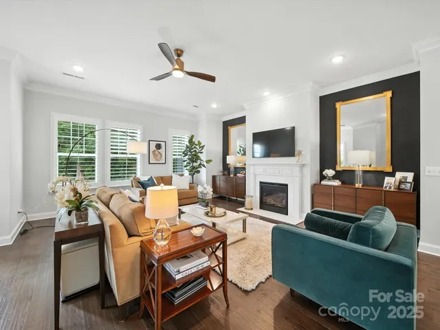 a living room with furniture kitchen view and a chandelier