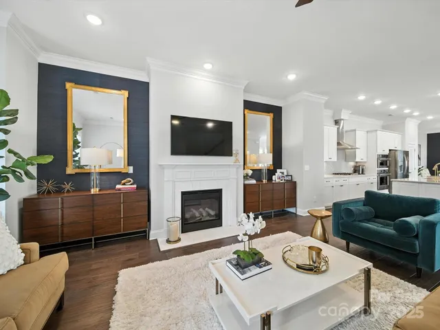 a kitchen with kitchen island granite countertop a stove a sink a center island and living room view