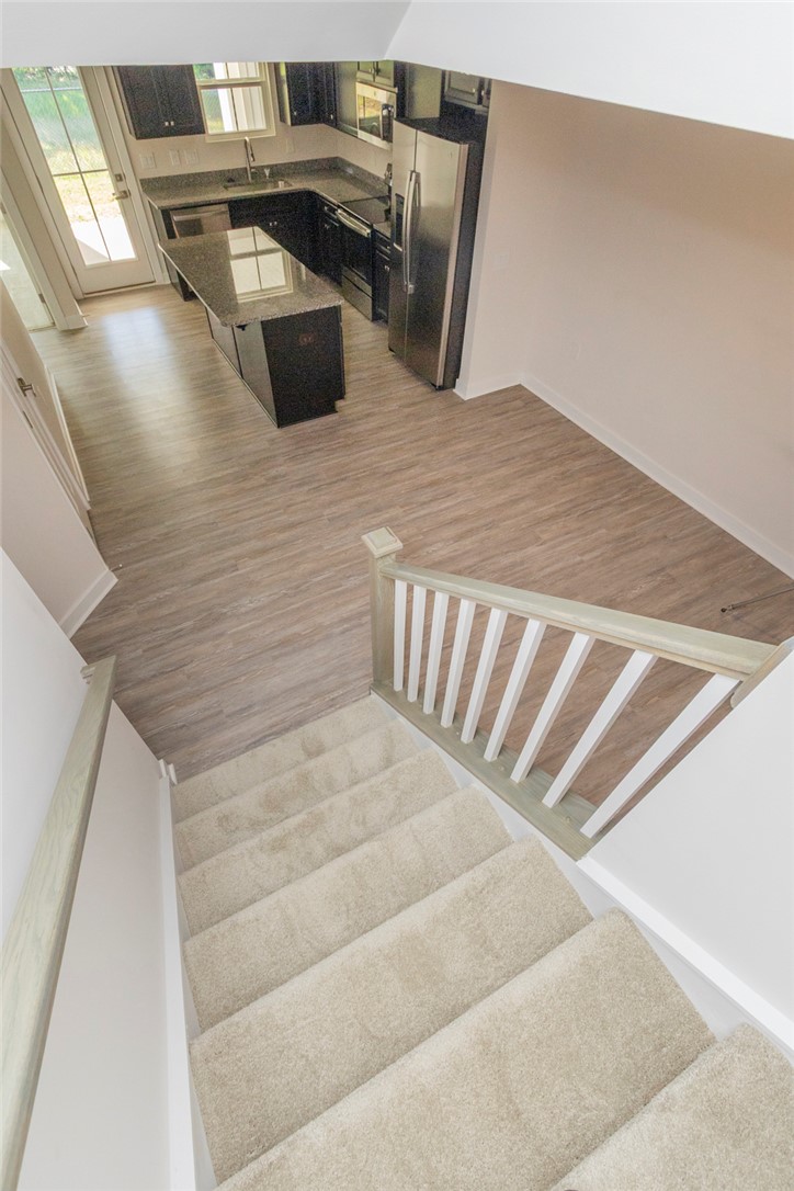 233 Scenic Road Anderson, SC 29621 - Photo 47 of 50 Descend carpeted stairs into an inviting kitchen area featuring an island and modern appliances.