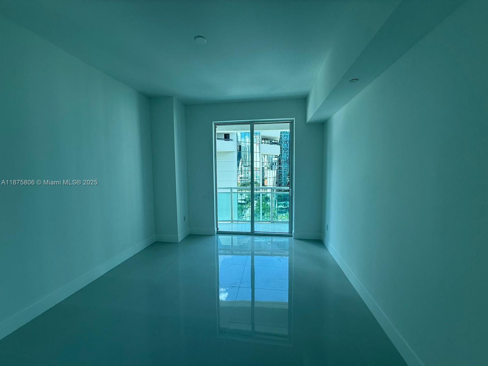 951 Brickell Avenue, Unit 1010 Miami, FL 33131 - Photo 12 of 23 a view of an empty room with wooden floor and a window