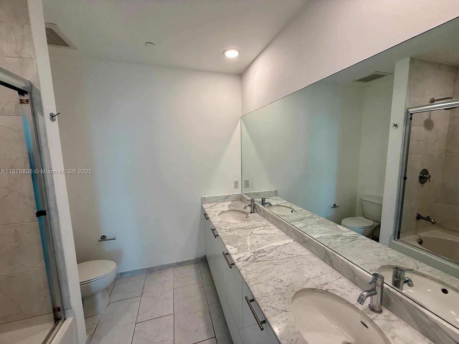 951 Brickell Avenue, Unit 1010 Miami, FL 33131 - Photo 14 of 23 a bathroom with a granite countertop sink a mirror and toilet