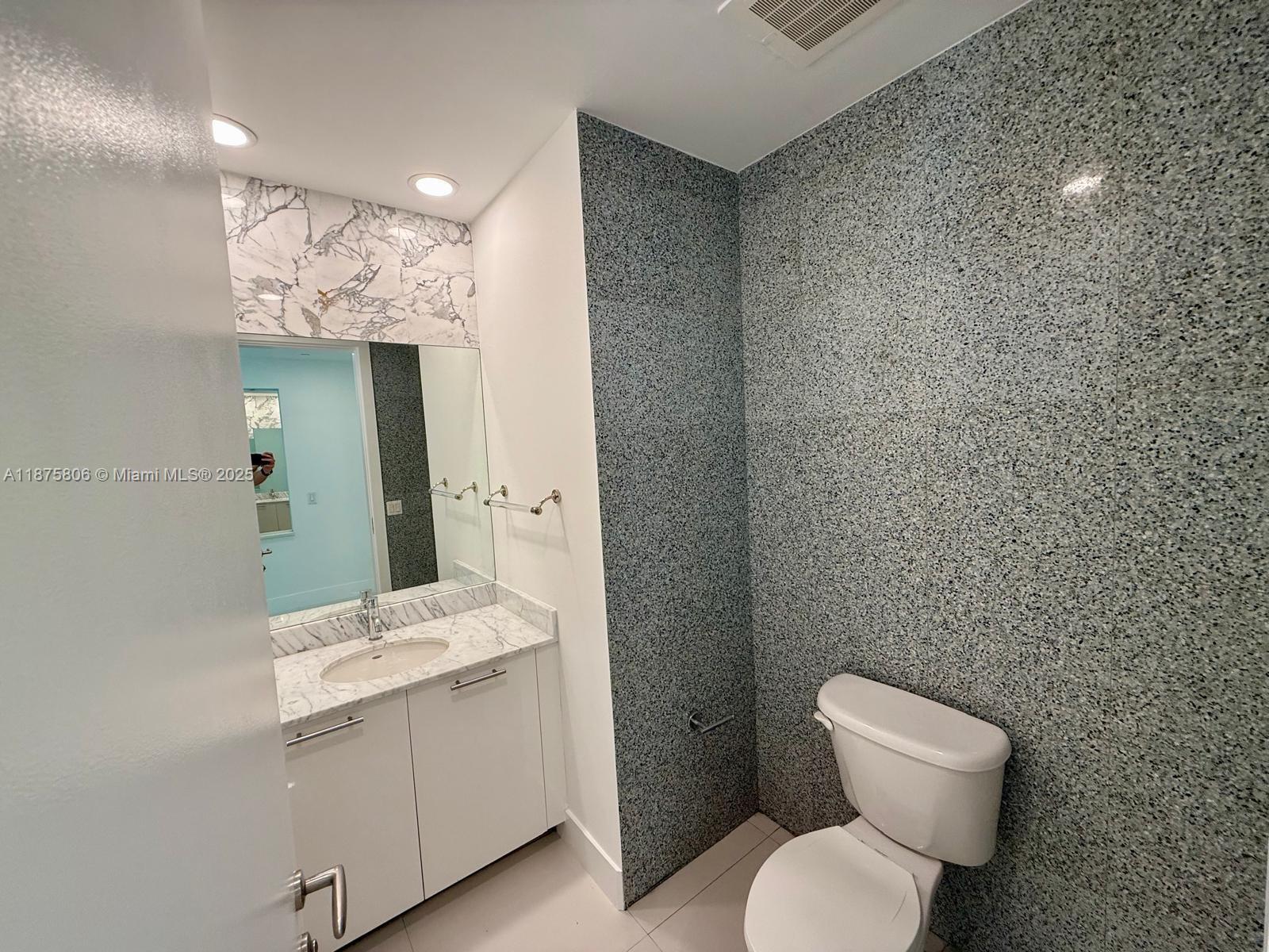 951 Brickell Avenue, Unit 1010 Miami, FL 33131 - Photo 15 of 23 a bathroom with a toilet sink and mirror
