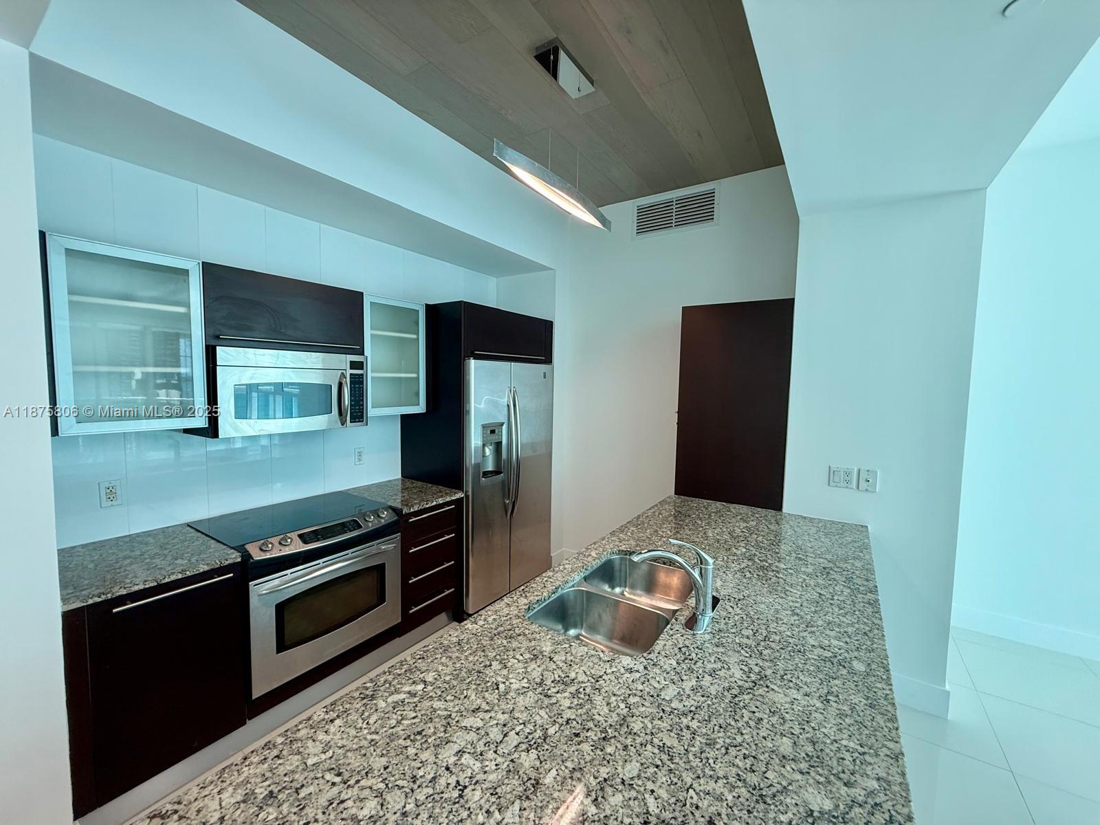 951 Brickell Avenue, Unit 1010 Miami, FL 33131 - Photo 3 of 23 a kitchen with stainless steel appliances granite countertop a stove a sink and a refrigerator
