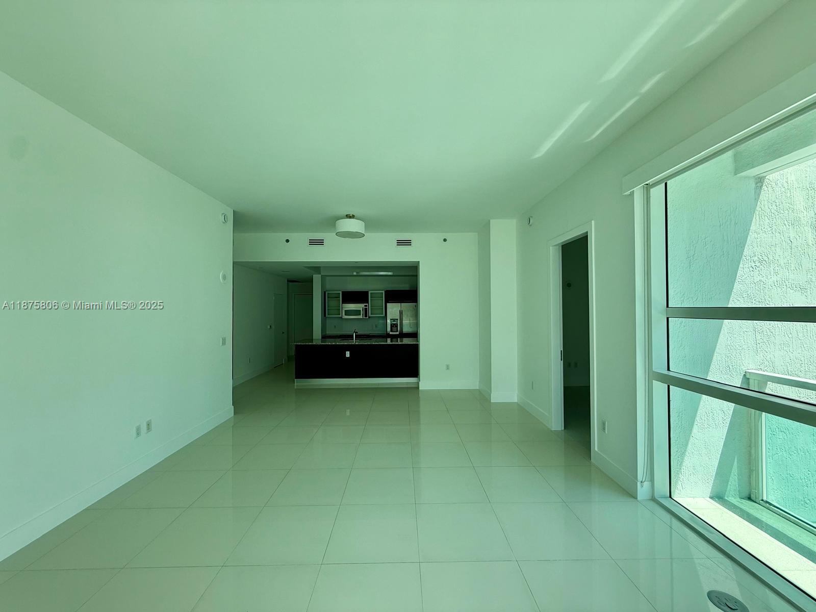 951 Brickell Avenue, Unit 1010 Miami, FL 33131 - Photo 7 of 23 a view of an empty room with a fireplace and a window