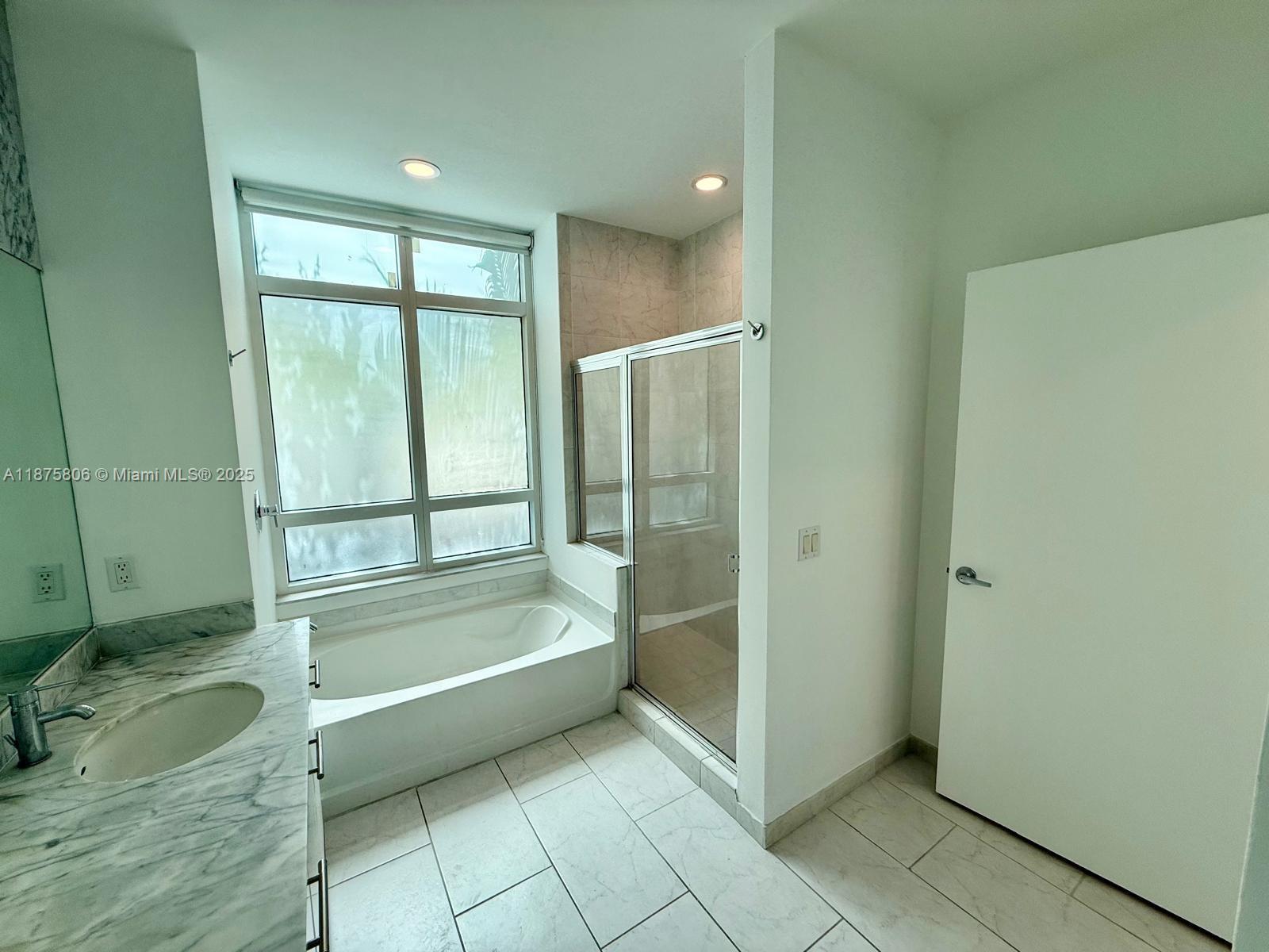 951 Brickell Avenue, Unit 1010 Miami, FL 33131 - Photo 10 of 23 a bathroom with a bathtub and a shower