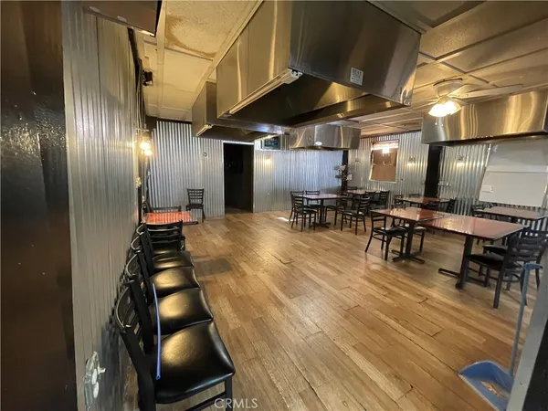 a room with lots of wooden furniture and stainless steel appliances