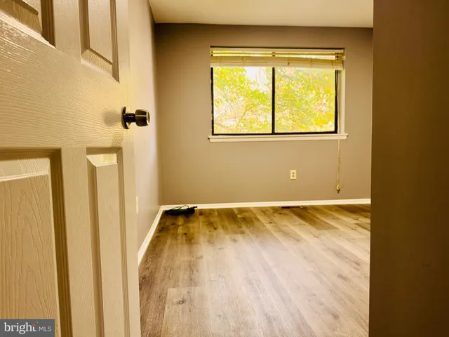 a view of a room with wooden floor and a window