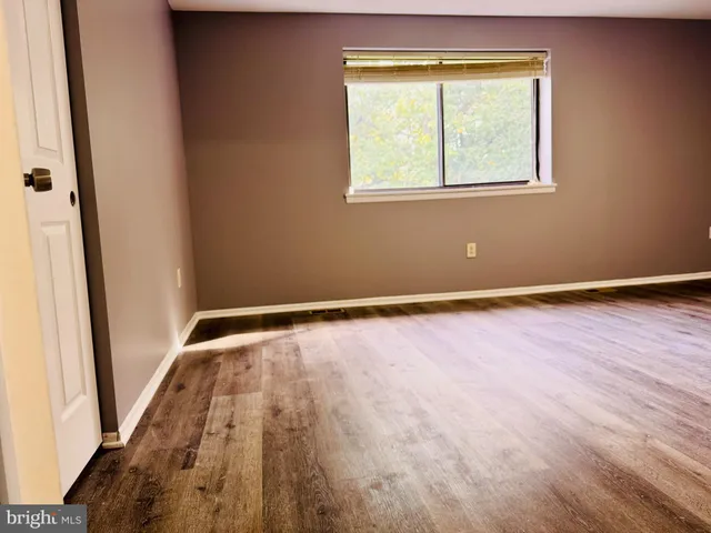 an empty room with wooden floor and a window