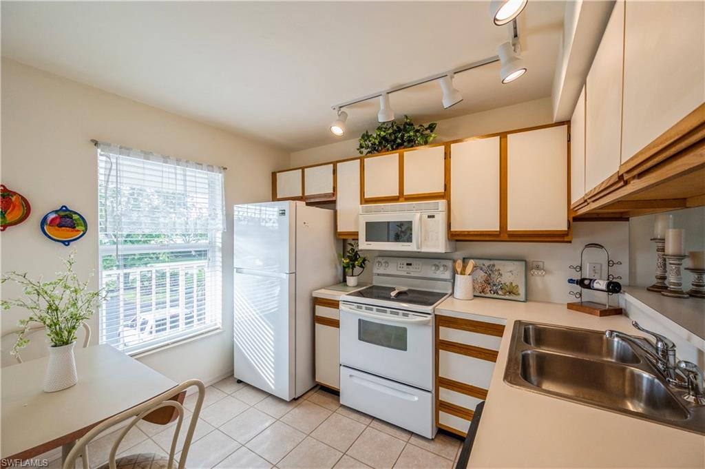 1325 Mainsail Drive, Unit 1213 Naples, FL 34114 - Photo 12 of 40 a kitchen with a refrigerator and a table