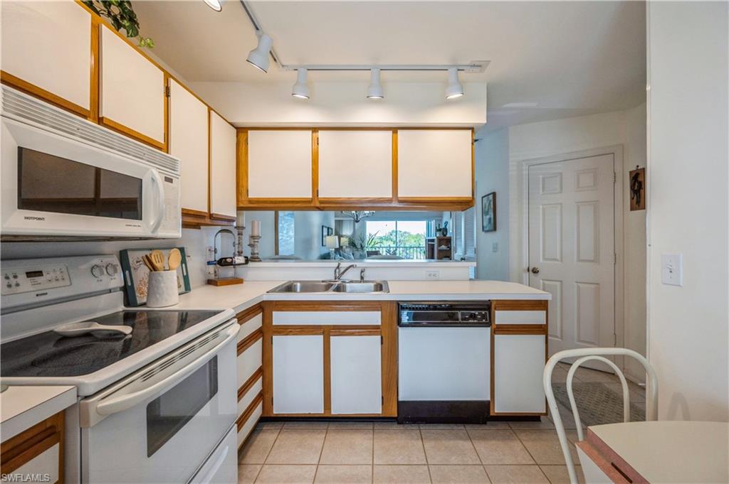 1325 Mainsail Drive, Unit 1213 Naples, FL 34114 - Photo 14 of 40 a kitchen with a sink and a stove top oven