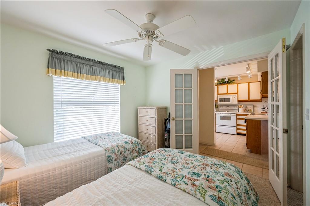 1325 Mainsail Drive, Unit 1213 Naples, FL 34114 - Photo 28 of 40 a bedroom with a bed and a dresser with mirror