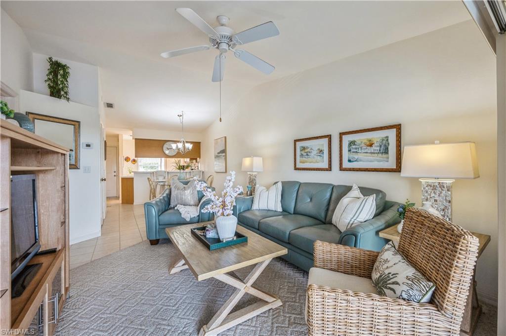 1325 Mainsail Drive, Unit 1213 Naples, FL 34114 - Photo 3 of 40 a living room with furniture a fireplace and a table