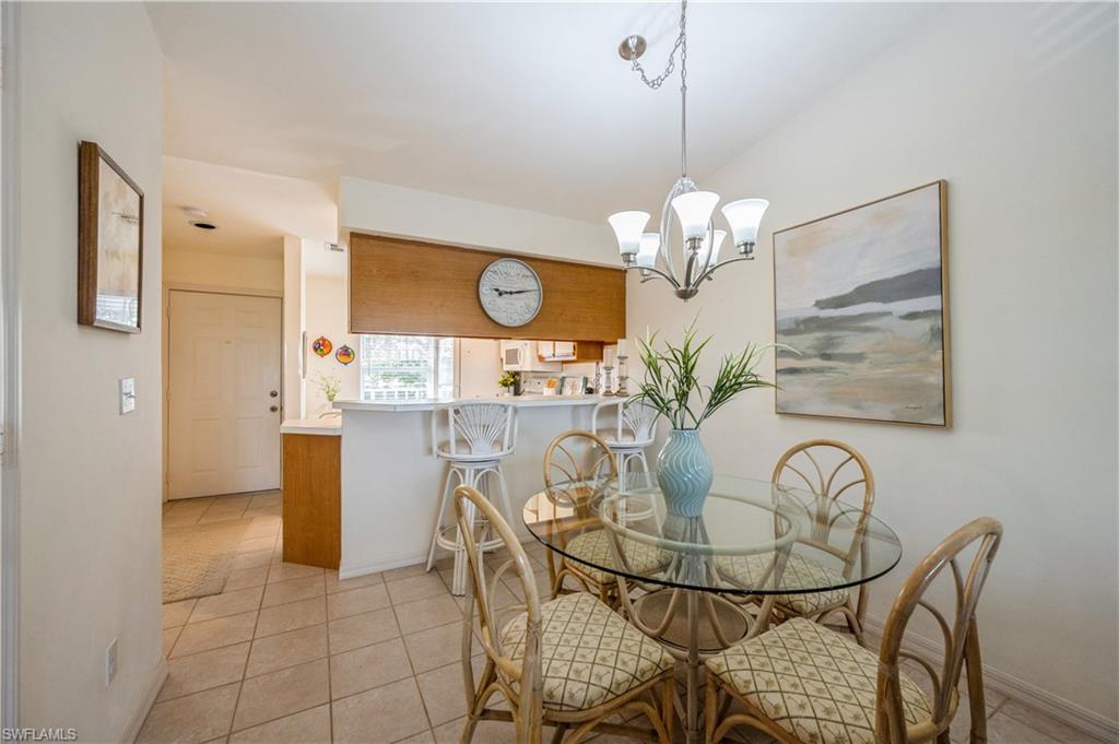 1325 Mainsail Drive, Unit 1213 Naples, FL 34114 - Photo 9 of 40 a view of a dining room with furniture and chandelier