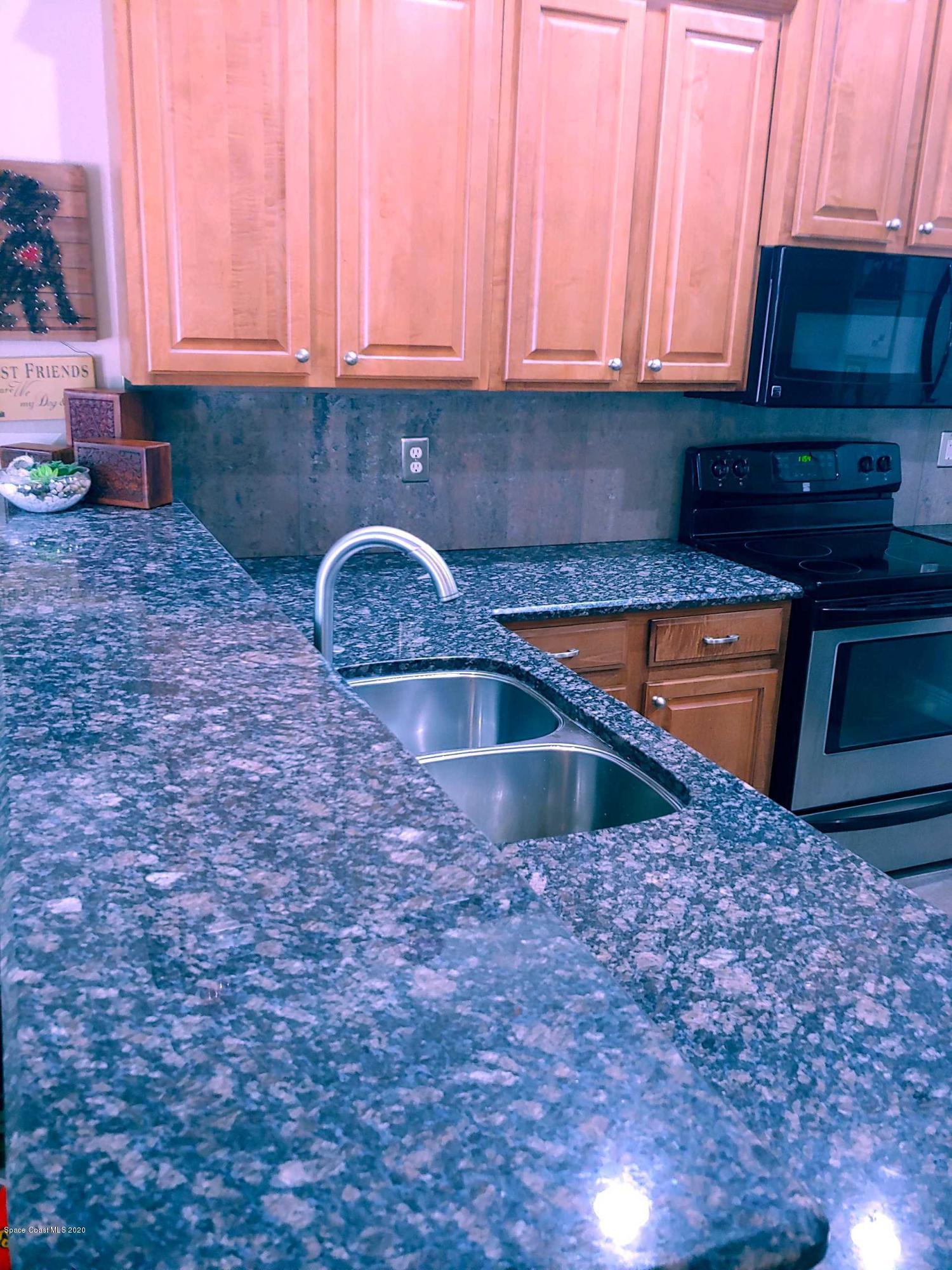 6791 Hartford Road Cocoa, FL 32927 - Photo 17 of 43 a kitchen with granite countertop a sink a stove and cabinets