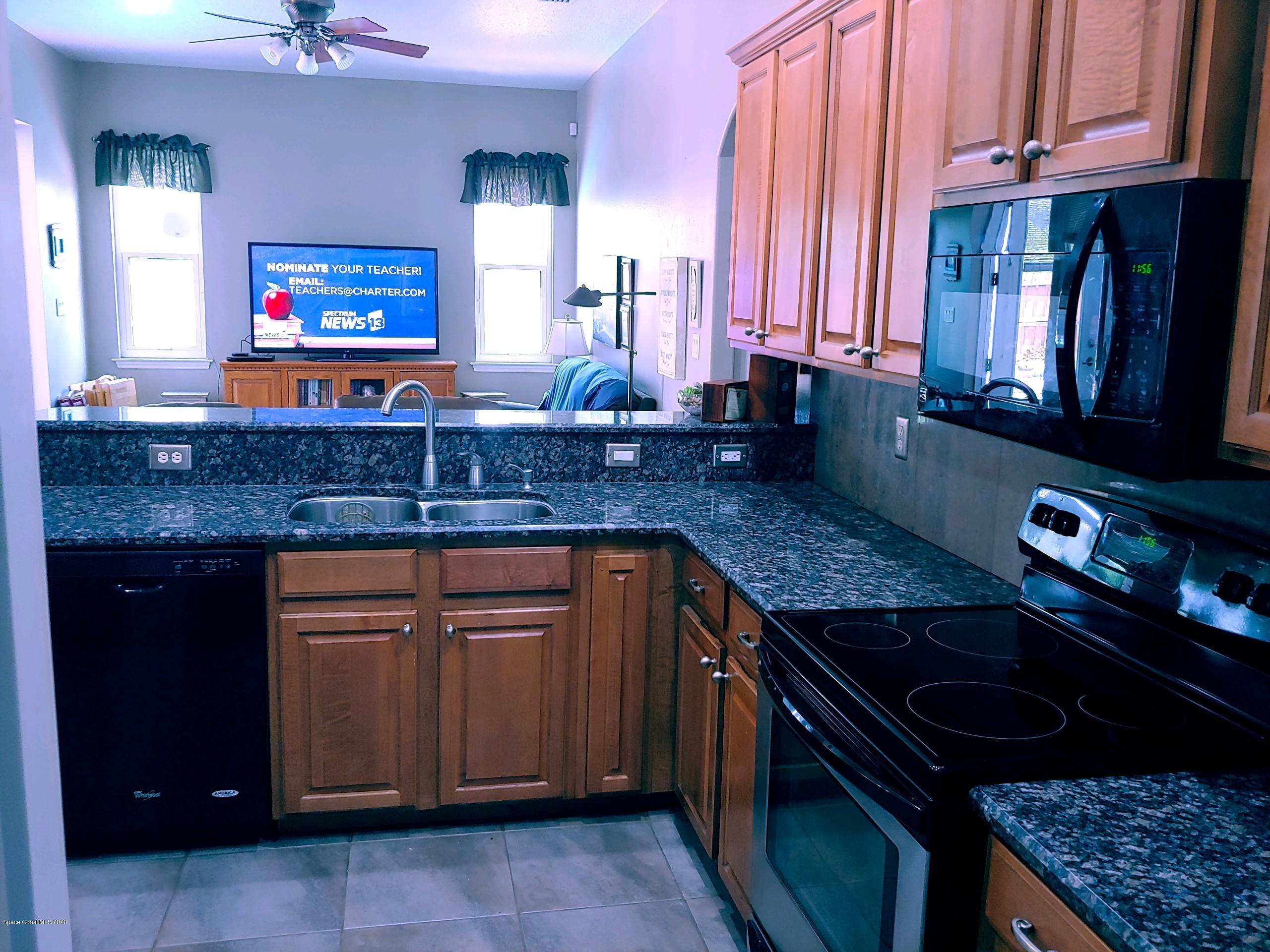 6791 Hartford Road Cocoa, FL 32927 - Photo 18 of 43 a kitchen with granite countertop a stove a sink and a microwave