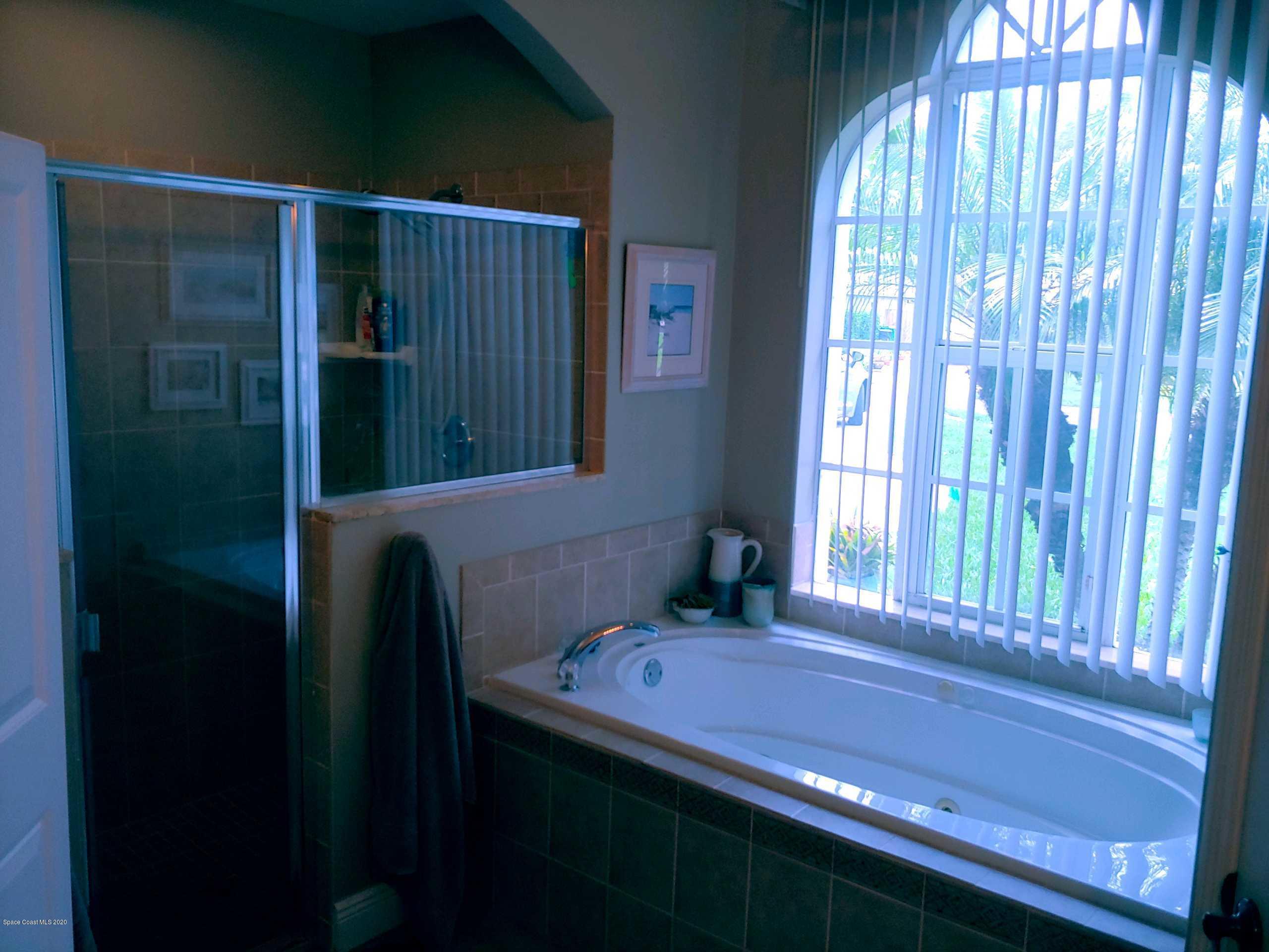 6791 Hartford Road Cocoa, FL 32927 - Photo 21 of 43 a bathroom with a bathtub and a window