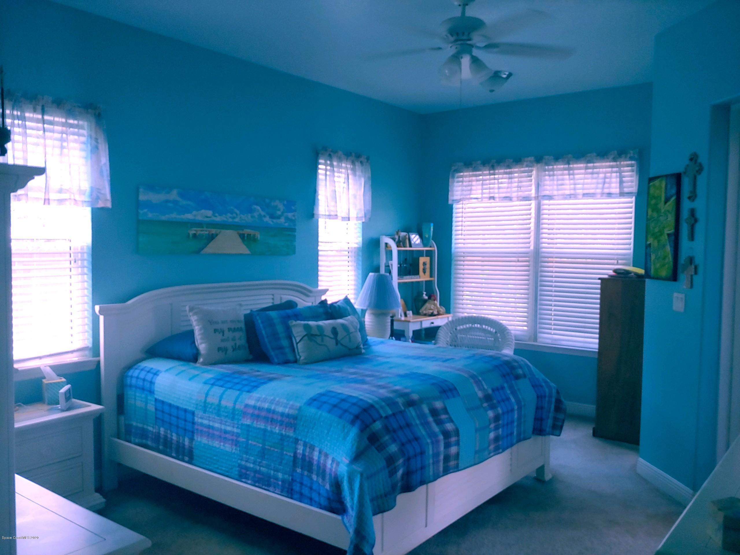 6791 Hartford Road Cocoa, FL 32927 - Photo 6 of 43 a large bed sitting in a bedroom next to a window and a chandelier