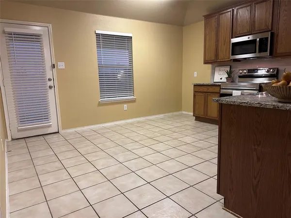 a kitchen with stainless steel appliances granite countertop a stove a sink dishwasher and a refrigerator