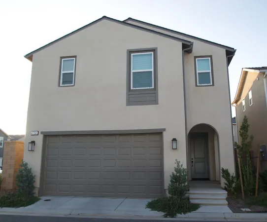 a front view of a house with plants