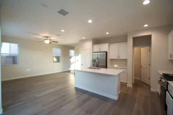 a view of kitchen with cabinets stainless steel appliances and wooden floor