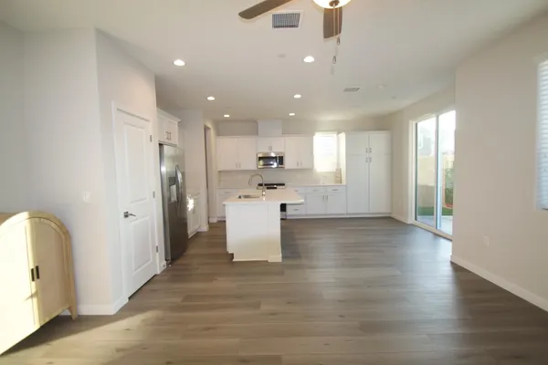 a view of a kitchen with a refrigerator and a stove top oven
