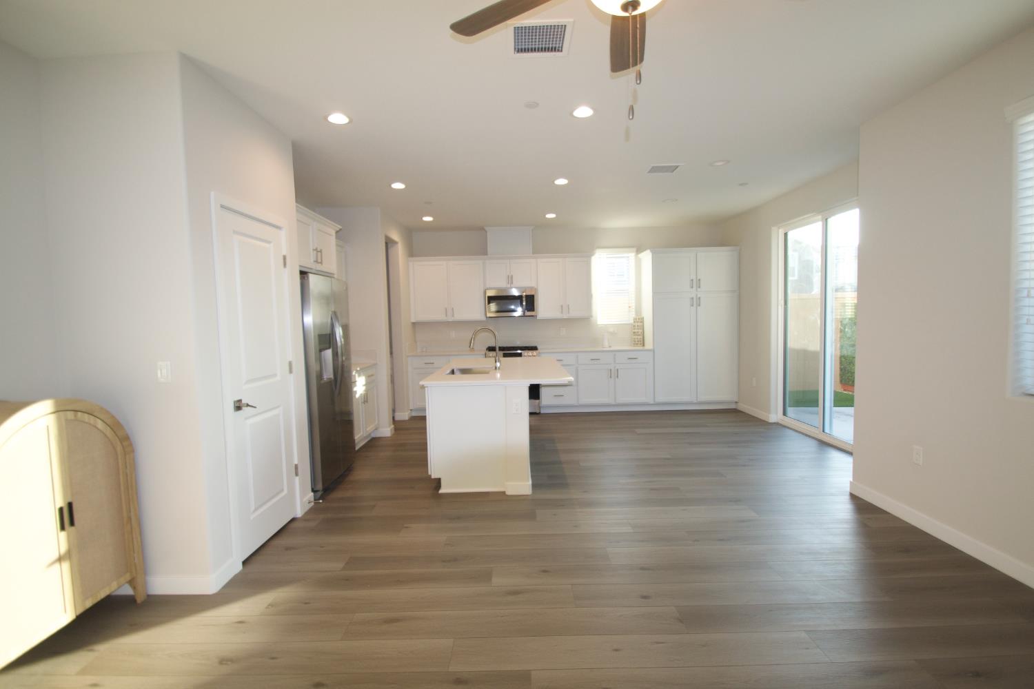 4154 Constance Road Madera, CA 93636 - Photo 8 of 23 a view of a kitchen with a refrigerator and a stove top oven