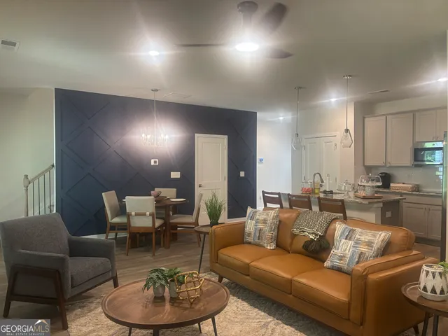 a living room with furniture a chandelier and a dining table