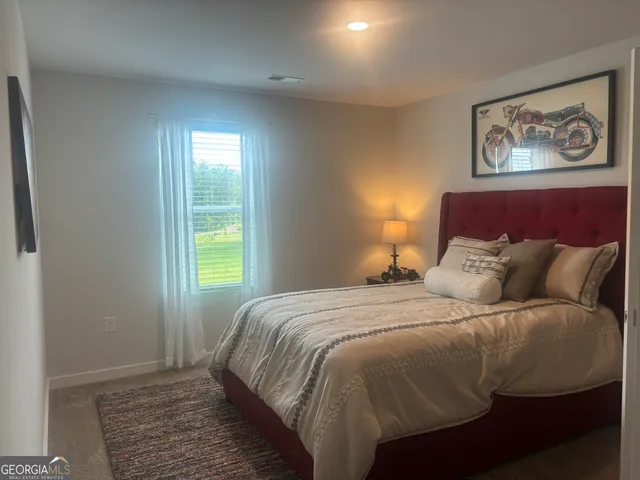 a bedroom with a large bed and paintings on the wall