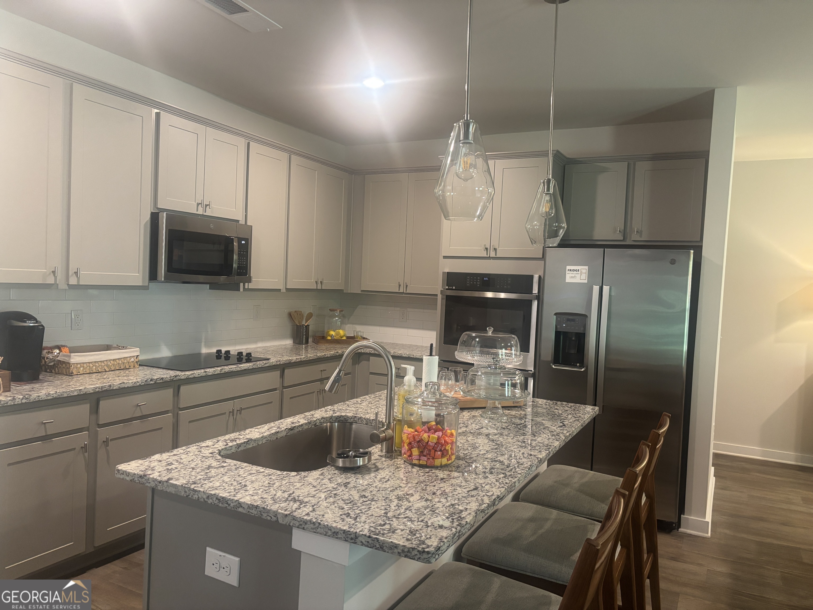5355 Tolar Road South Fulton, GA 30213 - Photo 4 of 37 a kitchen with kitchen island granite countertop a sink a counter space appliances and cabinets
