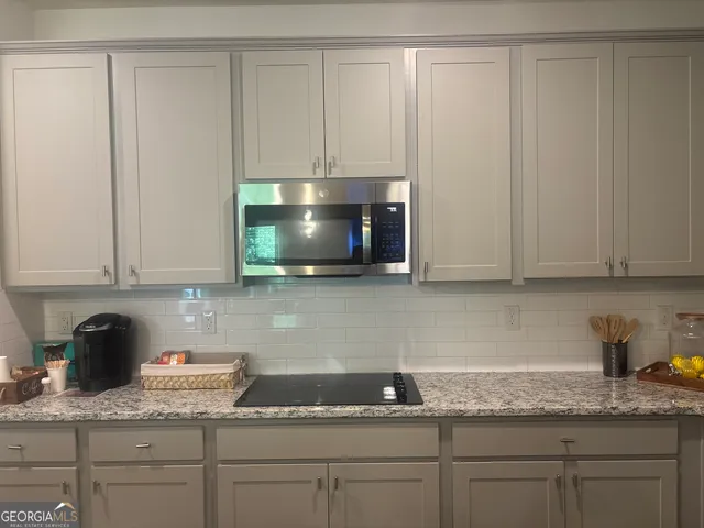 a kitchen with a stove a sink and cabinets