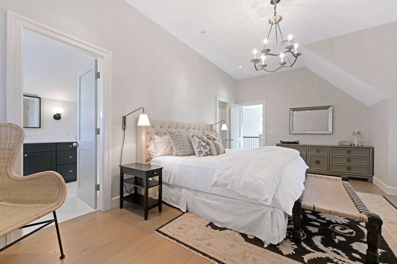 60 Jagger Lane Westhampton, NY 11977 - Photo 18 of 35 a spacious bedroom with a bed a chandelier and mirror