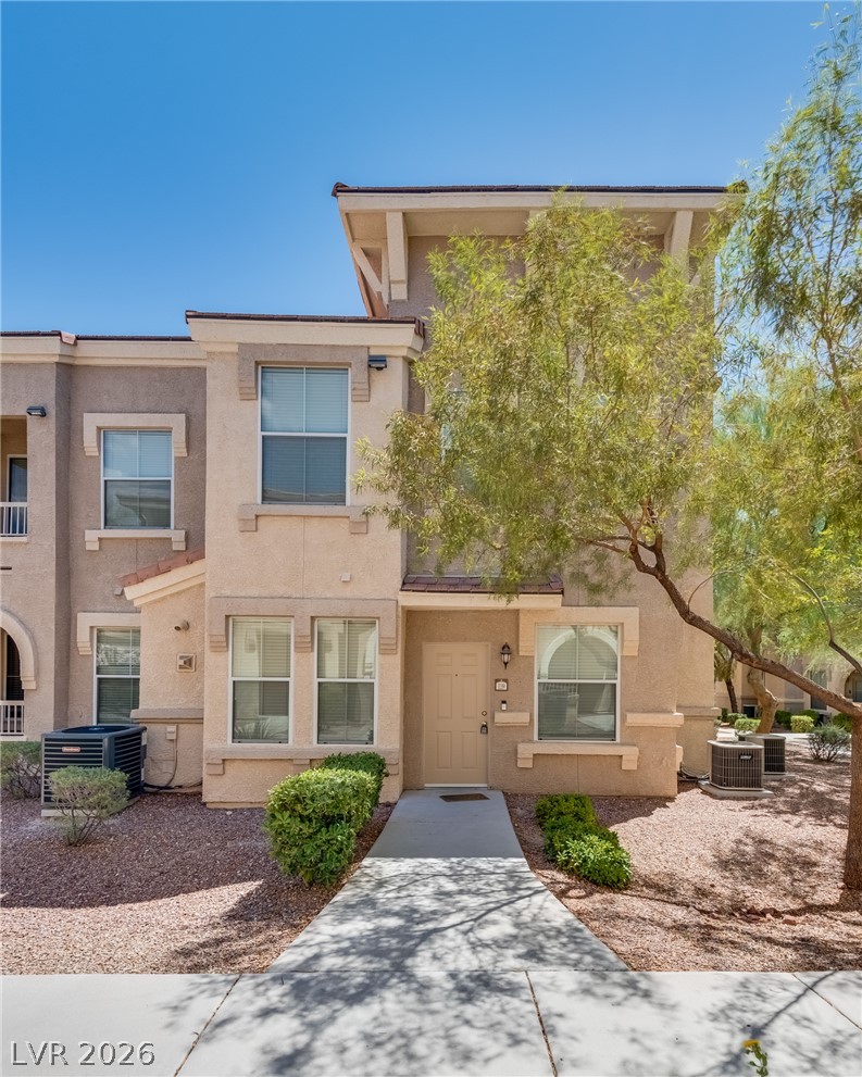 10550 West Alexander Road, Unit 1139 Las Vegas, NV 89129 - Photo 2 of 27 A welcoming entryway with a sidewalk leads to this charming residence featuring a warm-toned stucco exterior.