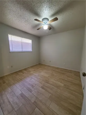 an empty room with windows and fan