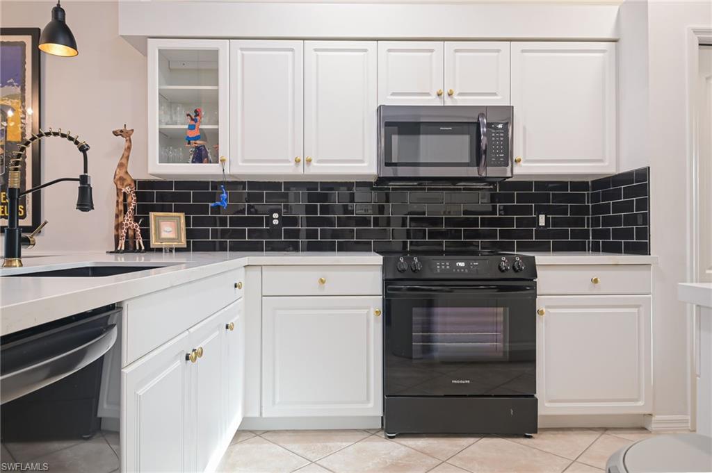 21533 Portrush Run Estero, FL 33928 - Photo 12 of 37 a kitchen with white cabinets and appliances