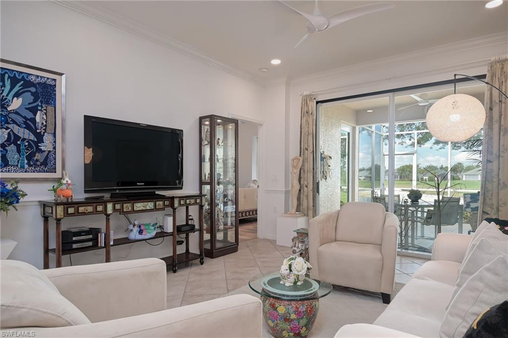 21533 Portrush Run Estero, FL 33928 - Photo 17 of 37 a living room with furniture a flat screen tv and a large window