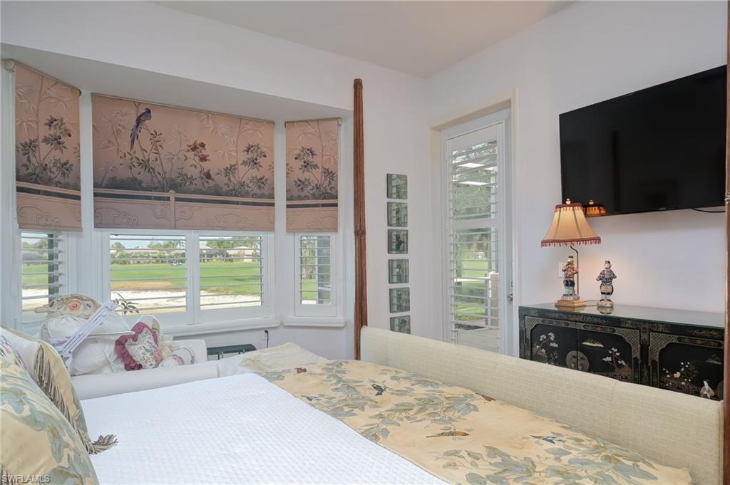 21533 Portrush Run Estero, FL 33928 - Photo 23 of 37 a bedroom with a bed a large window and flat screen tv