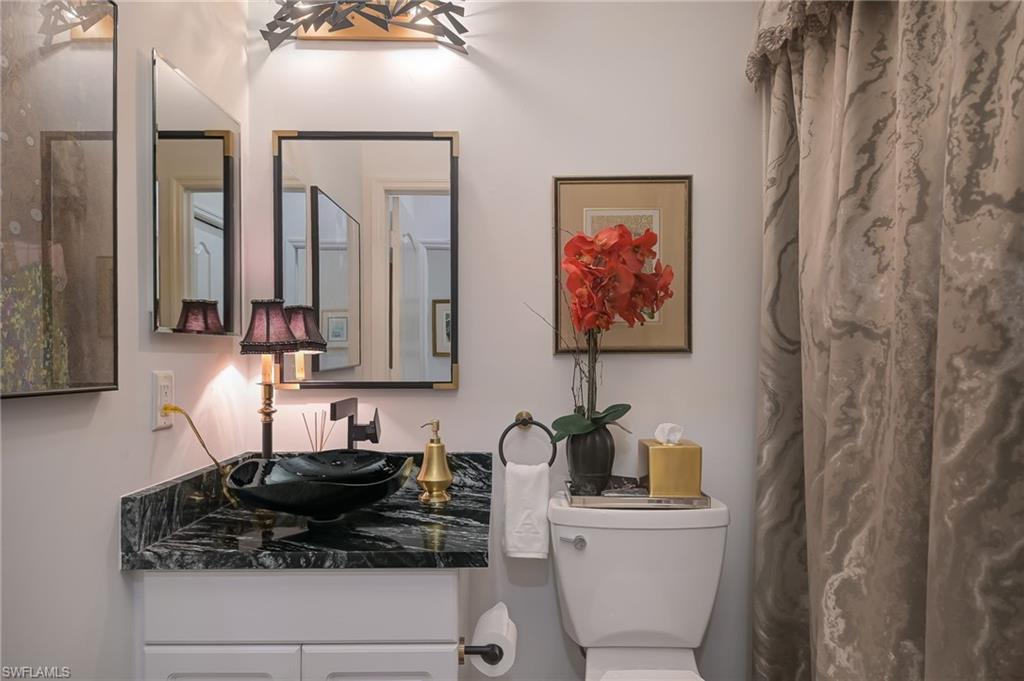 21533 Portrush Run Estero, FL 33928 - Photo 26 of 37 a bathroom with a toilet a sink and mirror