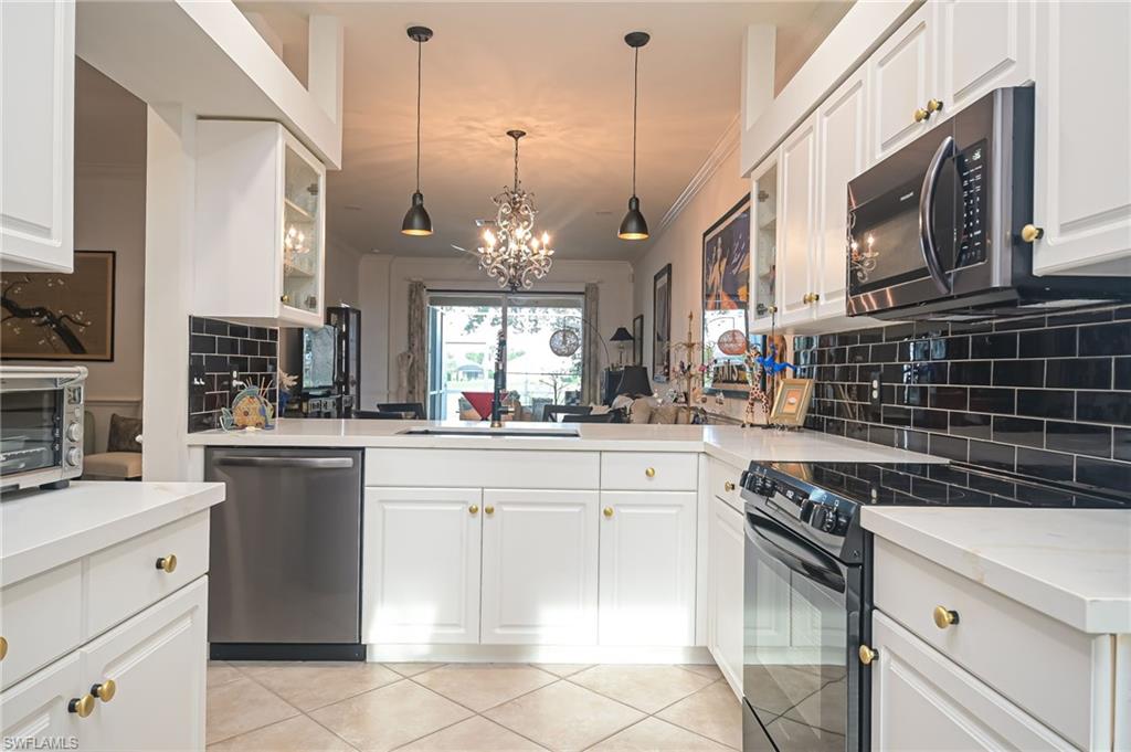 21533 Portrush Run Estero, FL 33928 - Photo 10 of 37 a kitchen with a stove and a microwave
