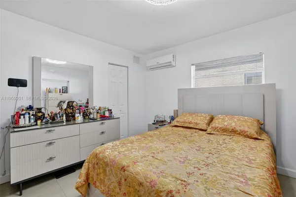 a bedroom with a bed and a large mirror on the dresser