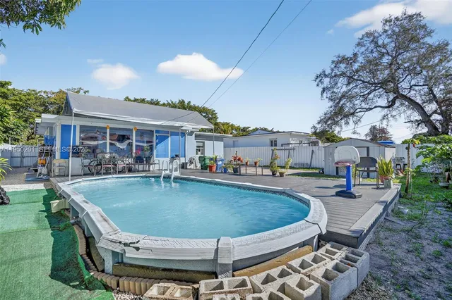 a swimming pool view with a seating space and a garden