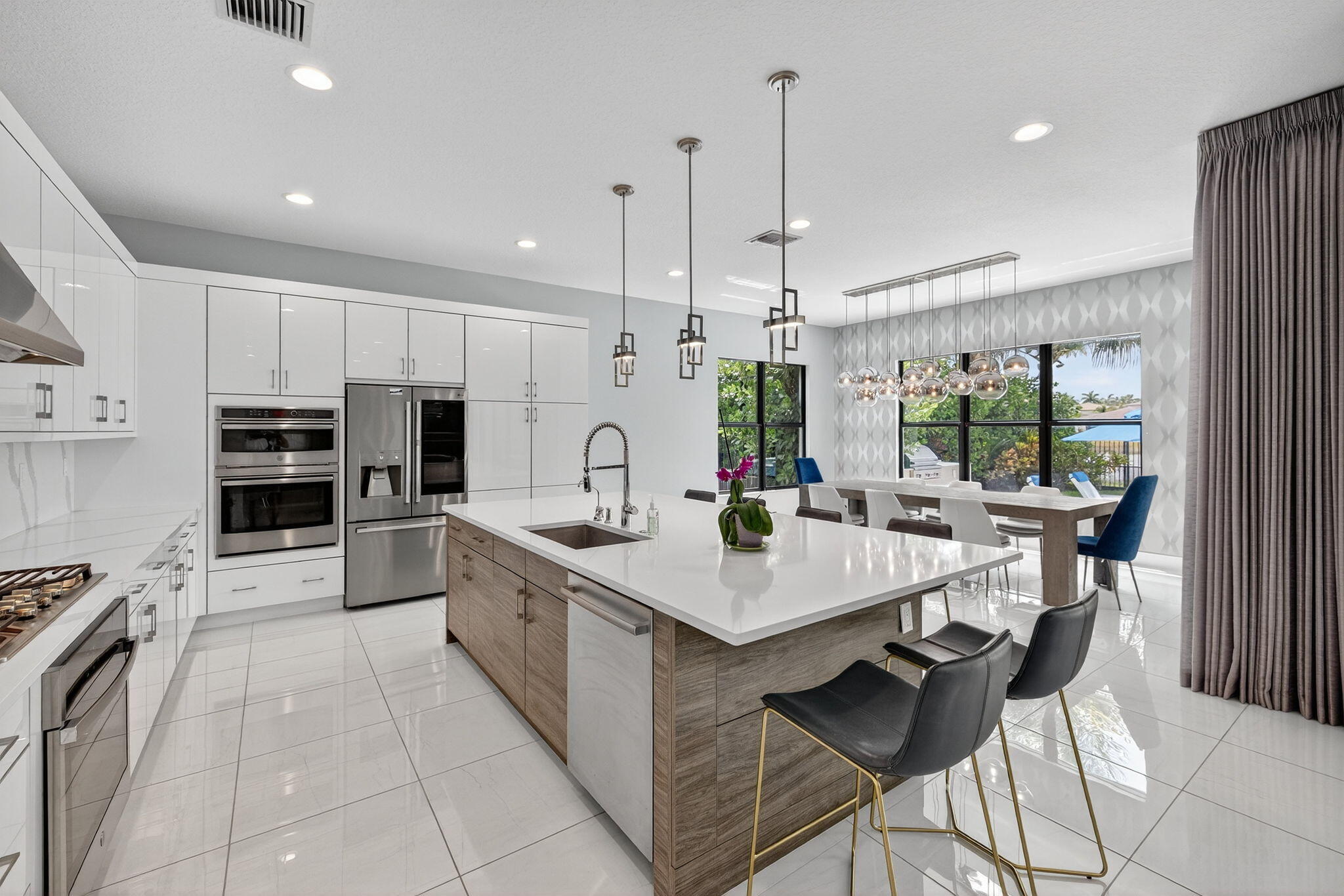 8618 Tower Bridge Court Boca Raton, FL 33496 - Photo 13 of 53 a kitchen with stainless steel appliances a stove a sink a oven a dining table and chairs