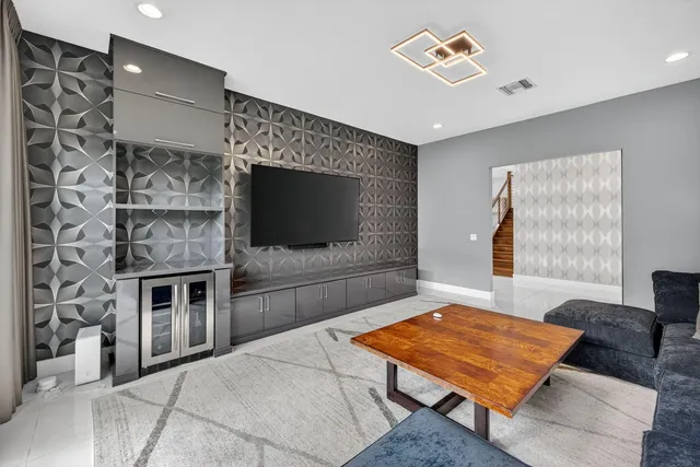 a spacious bedroom with a bed and a flat tv screen on the dresser